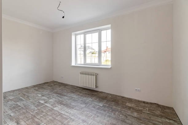 An after-flooring view of the room features a polished wooden floor, creating a bright and airy atmosphere.