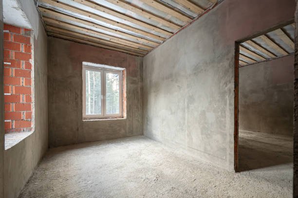 A vacant room showcasing a brick wall and a window, emphasizing the work process before our flooring project.