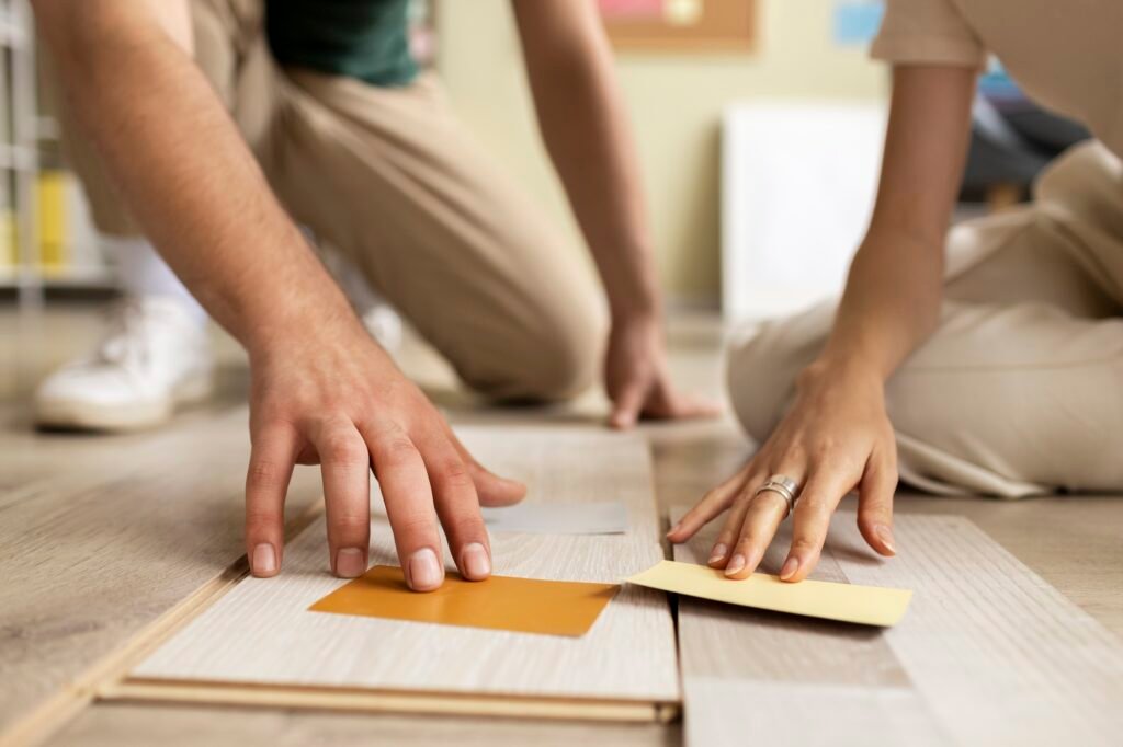 Experts seated on the floor, working together on flooring, demonstrating teamwork and concentration.